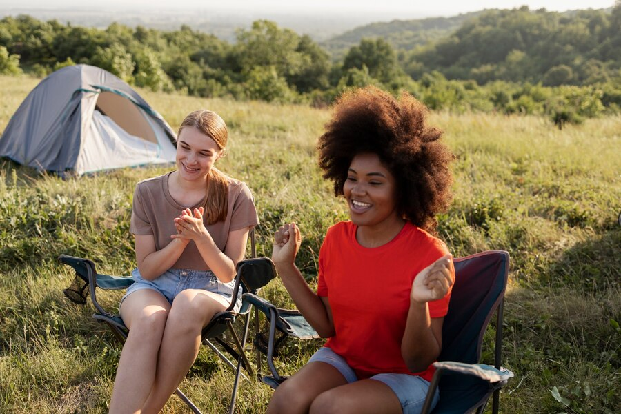 2 femmes asssises dans des chaises de camping dans la nature